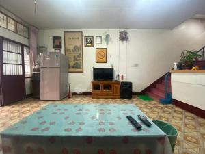 a living room with a table and a refrigerator at 華園大旅社臺東縣旅館002號 in Dawu