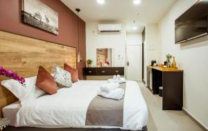 贝尔谢巴The Negev Hotel By Domus的卧室配有一张白色大床和红色的墙壁