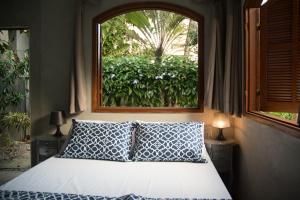 a bedroom with a bed with a window at Jardim Secreto Guest House in Búzios +96 photos