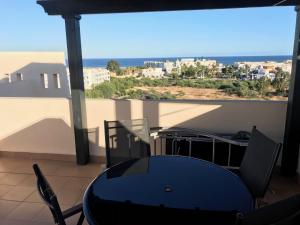 a table and chairs on a balcony with a view of the ocean at Atico con piscina privada y vistas al mar in Vera