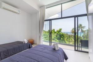 a bedroom with two beds and a large window at Villa Zen Sushi in Lamai