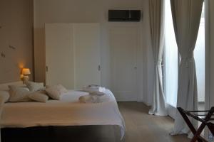 a bedroom with a bed with white sheets and a window at B&b Mondello Resort in Palermo