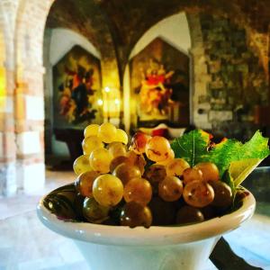 a bowl of grapes sitting on a table at Residenza Santa Maria In Borraccia in Magliano in Toscana