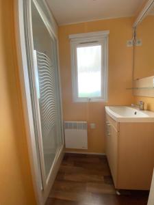 ein Badezimmer mit Dusche und Waschbecken und einem Fenster in der Unterkunft MOBIL HOME 43 dans Camping 4 Etoiles in Gastes