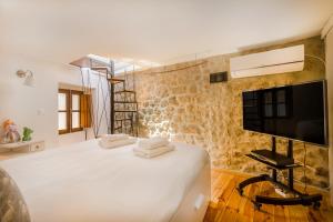 a bedroom with a bed and a flat screen tv at Casa da Pedra - Monsanto in Monsanto