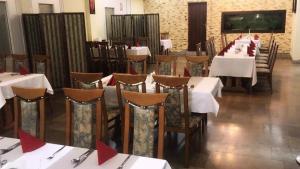 a dining room with tables and chairs with red napkins at Hotel U Witaszka in Czosnów
