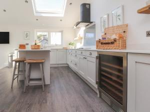 a kitchen with white cabinets and a counter top at Ghyll Cottage in Milnthorpe