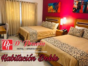 duas camas num quarto de hotel com uma parede vermelha em Dpravia Hotel SRL em Baní