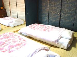 three beds in a room with blue walls at Tokuheian in Kyoto