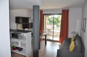 a living room with a couch and a table at Mas de Valrugues Holifrance in Saint-Rémy-de-Provence