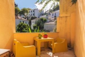 辛特拉的住宿－卡薩達潘多酒店，阳台上的小黄桌子和椅子