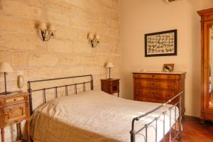 een slaapkamer met een bed en twee dressoirs bij Au Saint Roch - Hôtel et Jardin in Avignon