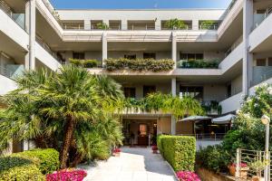 an external view of a building with palm trees and flowers at Hotel Idania in Bardolino