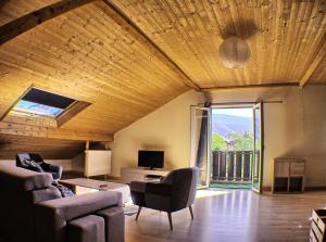 a living room with a couch and chairs and a tv at Le Gîte du Pontvys in Marignier