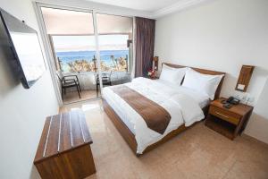 a hotel room with a bed and a large window at Joar Beach Hotel in Aqaba