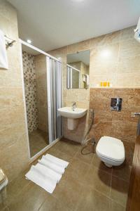 a bathroom with a toilet and a sink and a shower at Joar Beach Hotel in Aqaba