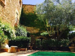 a swimming pool in a yard next to a building at Casa Migdia in Sant Jordi Desvalls