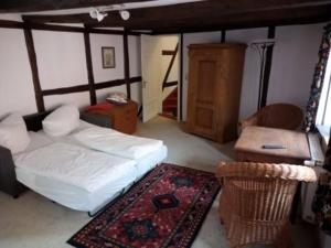 a living room with a bed and a chair at Quartier am Brunnen in Quedlinburg