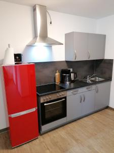 a kitchen with a red refrigerator and a stove at Landgasthof Fischer in Lichtenfels