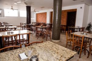 Hotel Lumiar في Coronel Fabriciano: غرفة طعام فارغة مع طاولات وكراسي