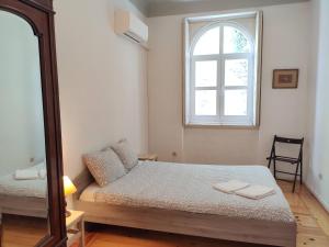 1 dormitorio con cama, espejo y ventana en Carolina M Apartment in front of Metro en Oporto