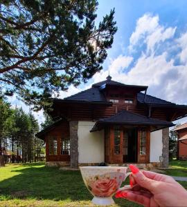 a person holding a bowl in front of a building at Vila Panić Zlatibor in Zlatibor