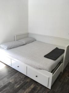 een wit bed in een kamer met een witte muur bij VanchigliArt Apartment in Turijn