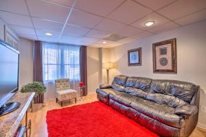 uma sala de estar com um sofá de couro e um tapete vermelho em Quiet Neighborhood Retreat - 13 Mi to Dtwn Atlanta em Mableton