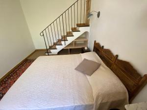 a bed in a room with a stair case at Le Caminol in Sisteron