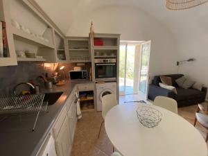 a kitchen with a table and a living room at Le Caminol in Sisteron