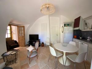 a kitchen and living room with a white table and chairs at Le Caminol in Sisteron
