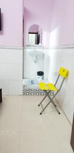 a yellow chair in a bathroom with a mirror at Hostel Garnet in Can Tho