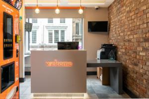 a welcome desk in a room with a brick wall at easyHotel Liverpool in Liverpool