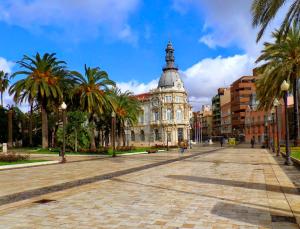 an empty street with a building with palm trees at CARTAGENAFLATS, Apartamentos Anfiteatro Romano 2B in Cartagena +19 photos