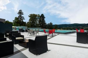 a patio with chairs and tables and a pool at Domus Lake Resorts in Villa Carlos Paz