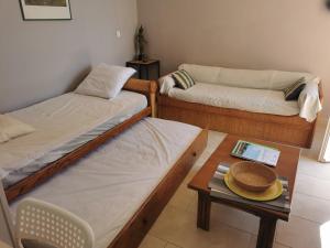 a room with two beds and a table with a hat on it at Appart "Pins & parasol", piscine chauffée et bain à remous in Taradeau