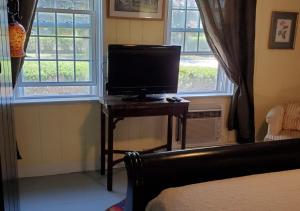 un televisor sentado en una mesa junto a una ventana en Rugosa Guest House, en Eastham