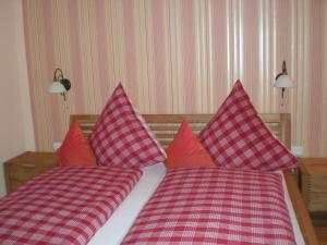 1 dormitorio con 2 camas y almohadas rojas y blancas en Gasthof Krone, en Schönau an der Brend