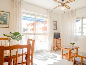 salon ze stołem i dużym oknem w obiekcie Apartamentos Irta Playa w mieście Alcossebre