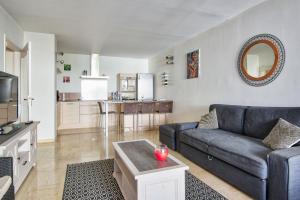 ein Wohnzimmer mit einem Sofa und einer Küche in der Unterkunft 1br w AC and terrace in the heart of Toulon near train station Welkeys in Toulon