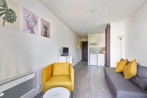 a living room with a couch and a yellow chair at Studio with terrace close to the Prado beach in Marseille Welkeys in Marseille