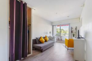 a living room with a gray couch and yellow pillows at Studio with terrace close to the Prado beach in Marseille Welkeys in Marseille