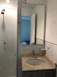 y baño con lavabo y espejo. en Morros Suites Apartamentos, en Cartagena de Indias