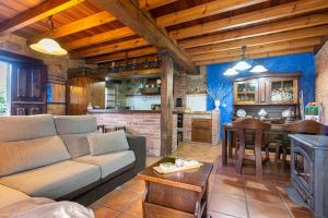 uma sala de estar com um sofá, uma mesa e uma cozinha em La Curuxa em Colunga