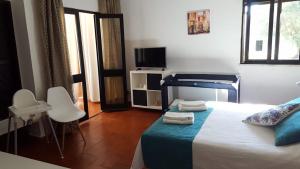 a bedroom with a bed and a television in it at Pedras D'el Rei - Vista Ria in Tavira