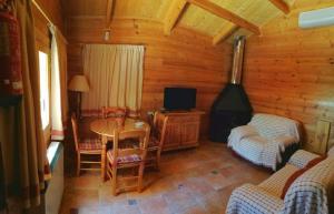 ein Wohnzimmer mit einem Tisch, Stühlen und einem Herd in der Unterkunft CASA DE MADERA ZUMACAR V in Cazorla