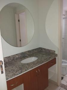 a bathroom with a sink and a mirror at APARTAMENTO JARDINS DAS THERMAS CALDAS NOVA in Caldas Novas