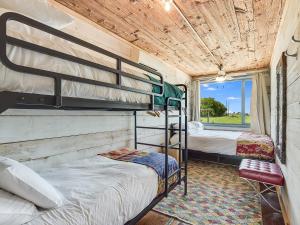 2 beliches num quarto com uma janela em FlopHouze Shipping Container Hotel em Round Top