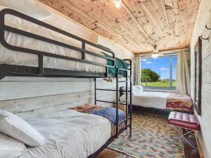 two bunk beds in a room with a window at FlopHouze Shipping Container Hotel in Round Top