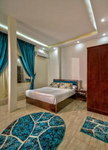sypialnia z łóżkiem z niebieskimi zasłonami i niebieskimi dywanami w obiekcie TuT Pyramids View w Kairze